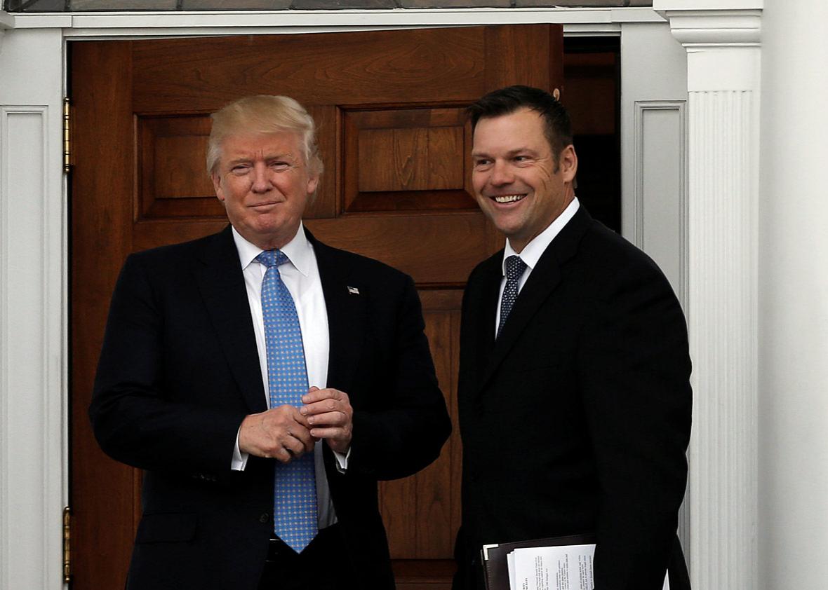 U.S. President-elect Donald Trump stands with Kansas Secretary of State Kris Kobach