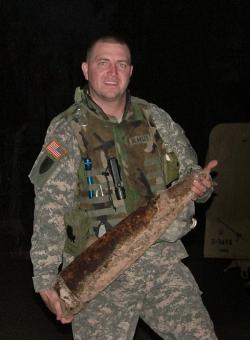 Staff Sgt. Richard "Doc" Blakley with an artillery shell mine he discovered