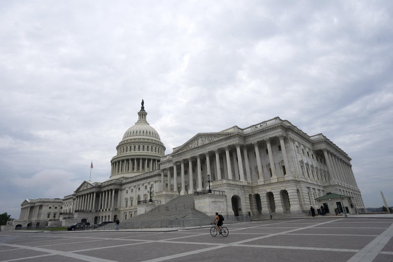 A bicyclist rides past the United States Capitol.