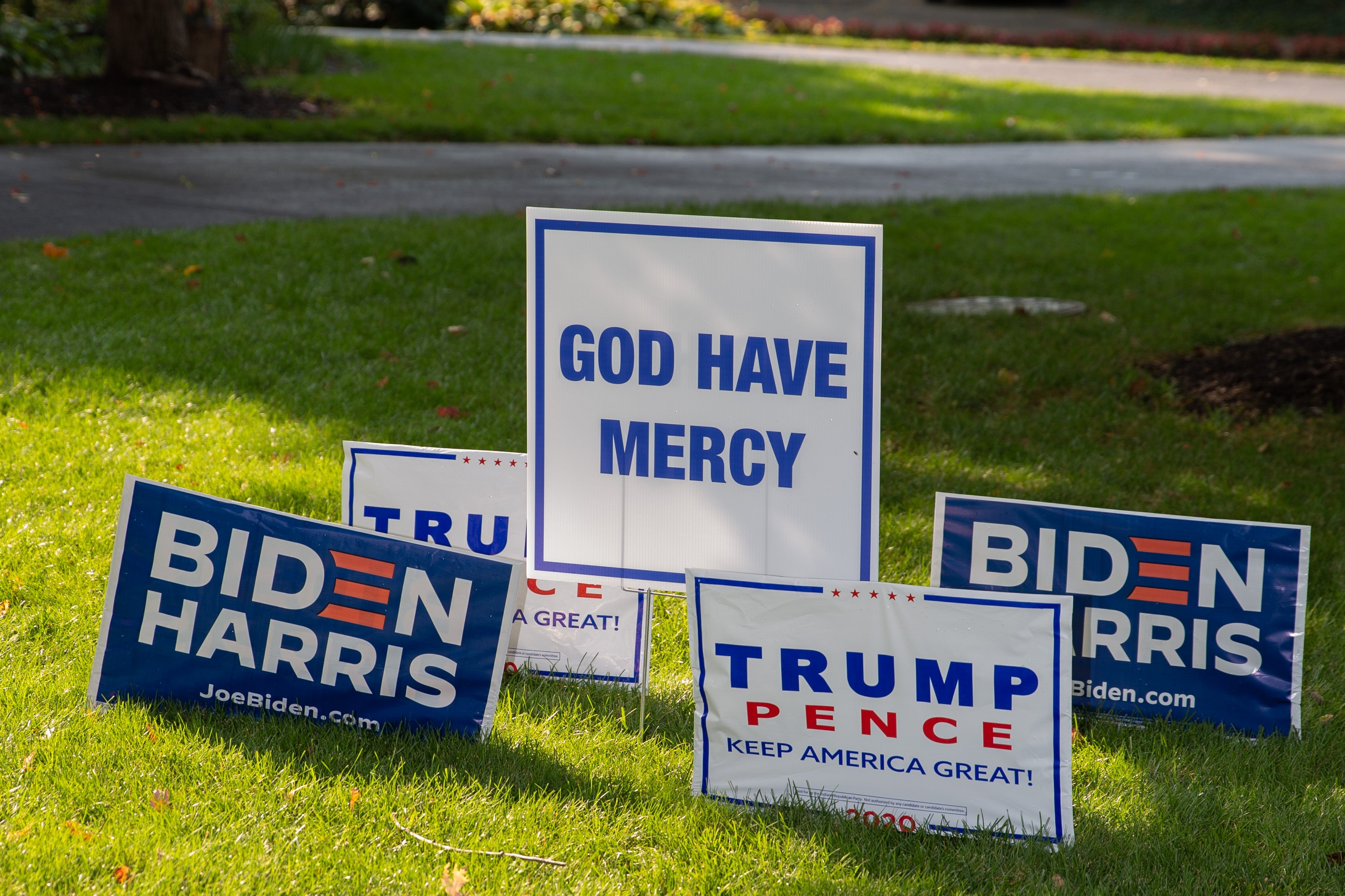 Biden and Trump lawn signs posted next to one another in the grass.