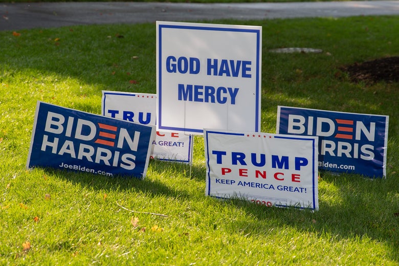 Biden and Trump lawn signs posted next to one another in the grass.