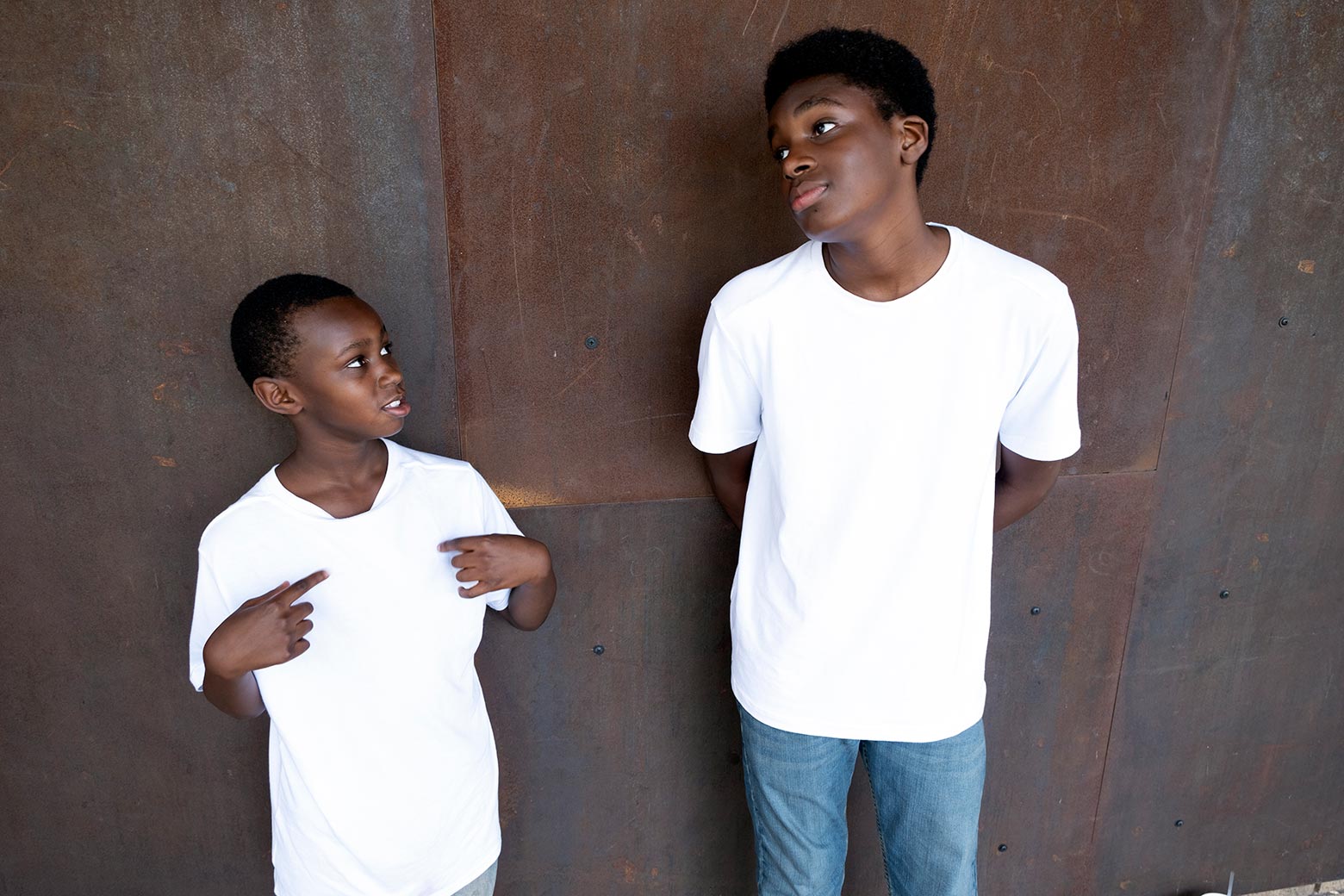 Da’Quaylon and one of his younger brothers stand against a wall