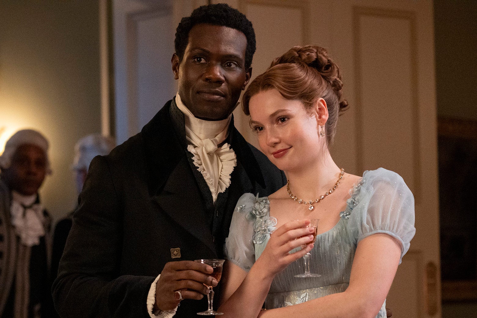 John and Francesca standing close to each other, holding drinks.