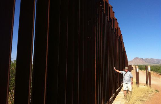 Glenn Spencer of American Border Patrol stands along the section of fencing right in front of his 104-acre compound.
