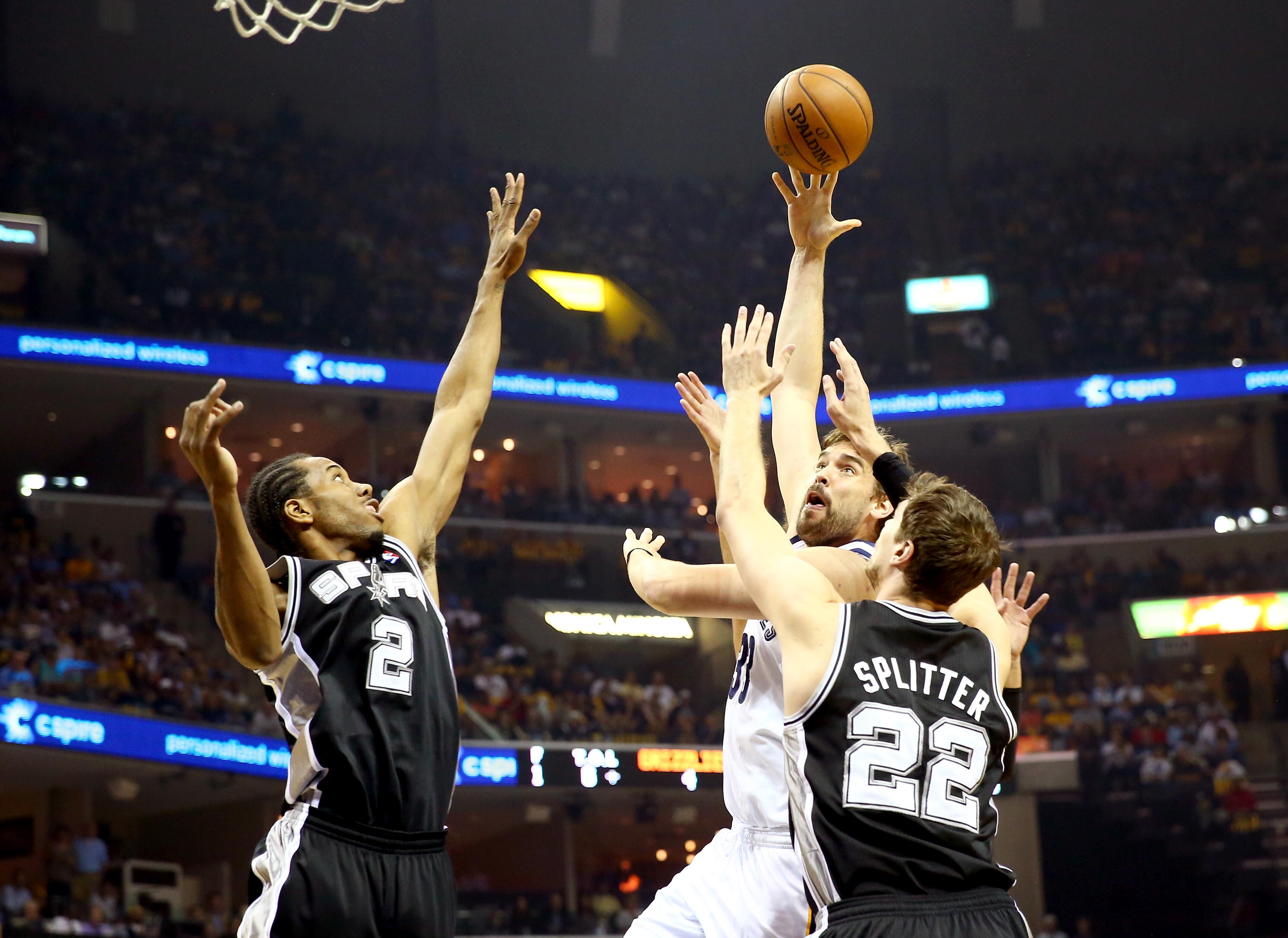 Marc Gasol, No. 33 of the Memphis Grizzlies, goes up for a shot against Tiago Splitter, No. 22 and Kawhi Leonard, No. 2 of the San Antonio Spurs, in the first quarter during Game 4 of the Western Conference Finals of the 2013 NBA Playoffs at the FedExForum on May 27, 2013, in Memphis, Tenn.