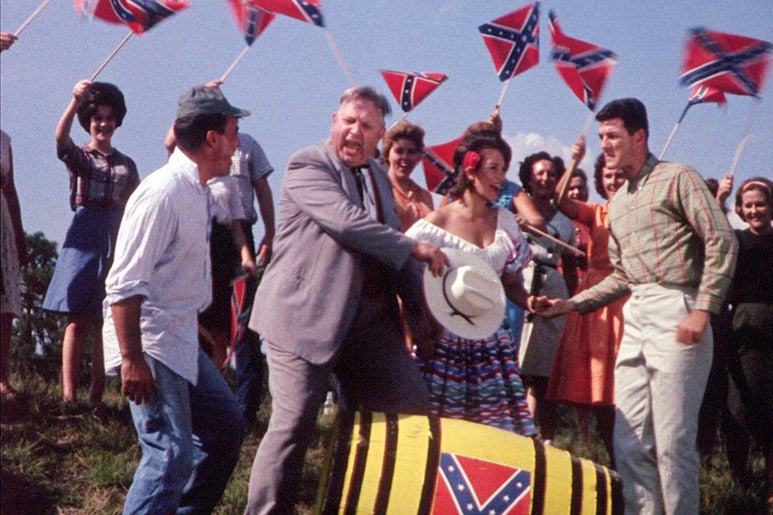 Still from 2000 Maniacs: People wave Confederate flags.