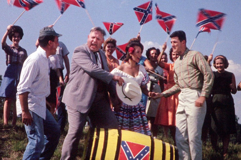 Still from 2000 Maniacs: People wave Confederate flags.
