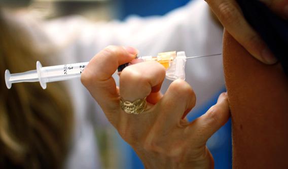 A doctor gives a 13-year-old girl an HPV vaccination