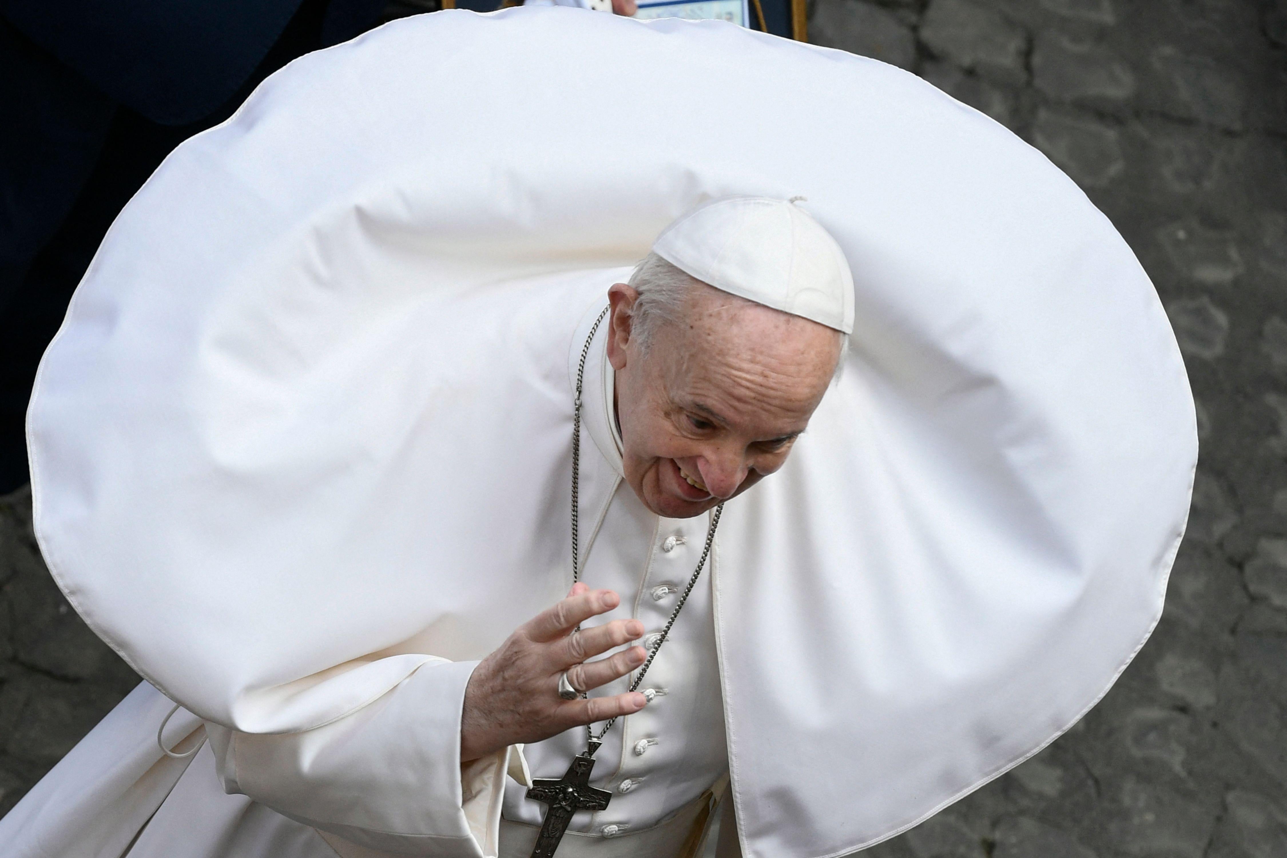 Pope Francis with his white cape billowing in a perfect circle around his head and shoulders