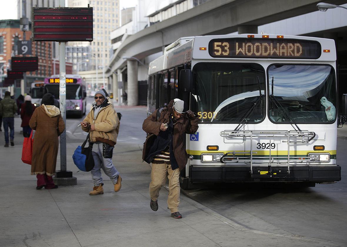 Commuters exit the 53 Woodward bus at the Rosa Parks bus terminal January 1, 2015 in Detroit, Michigan. 