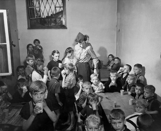 An American Army Public Health nurse with a group of children in a camp for Polish displaced persons at Bensheim,Germany on June 19, 1945.