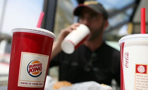 A Burger King customer drinks a soda while eating lunch at a Burger King.