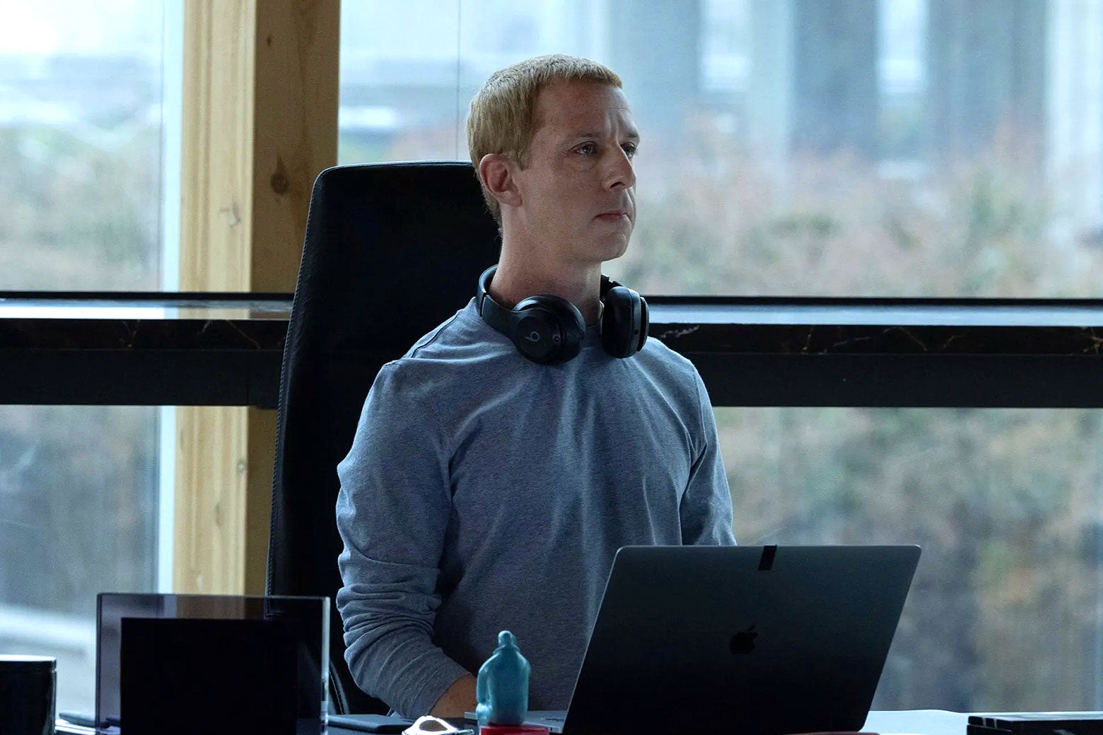 Strong as Zuckerberg sits at a desk by big windows wearing big headphones.