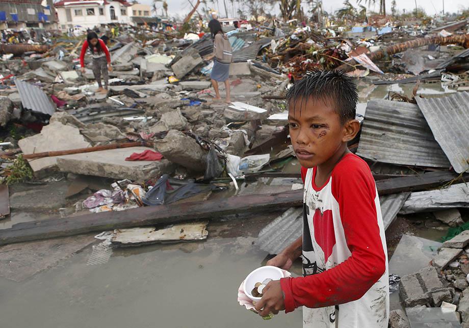 Residents gather coins and other salvageable materials from the ruins of houses after Super Typhoon Haiyan battered Tacloban city in central Philippines November 10, 2013.