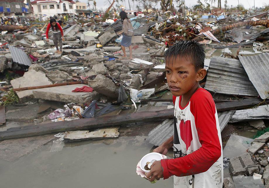 Residents gather coins and other salvageable materials from the ruins of houses after Super Typhoon Haiyan battered Tacloban city in central Philippines November 10, 2013. 