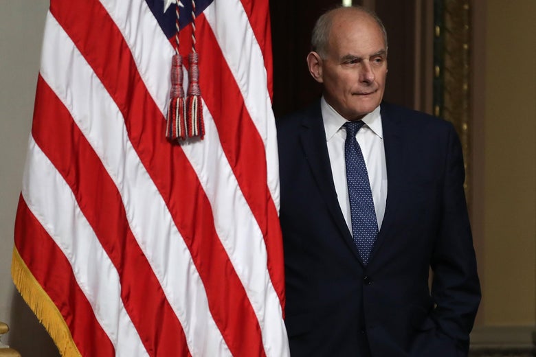 John Kelly stands next to an American flag.