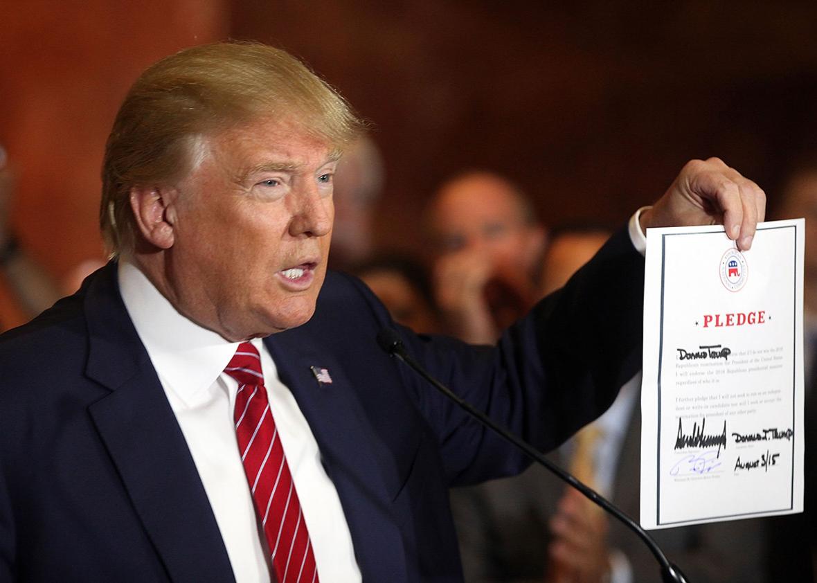 GOP presidential front-runner Donald Trump holds up the pledge he signed to support the eventual Republican nominee in the 2016 general election on Sept. 3, 2015, in New York City. 