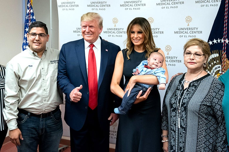 First lady Melania Trump holds a 2-month-old baby as she and President Donald Trump pose for photos and meet members of the Anchondo family.