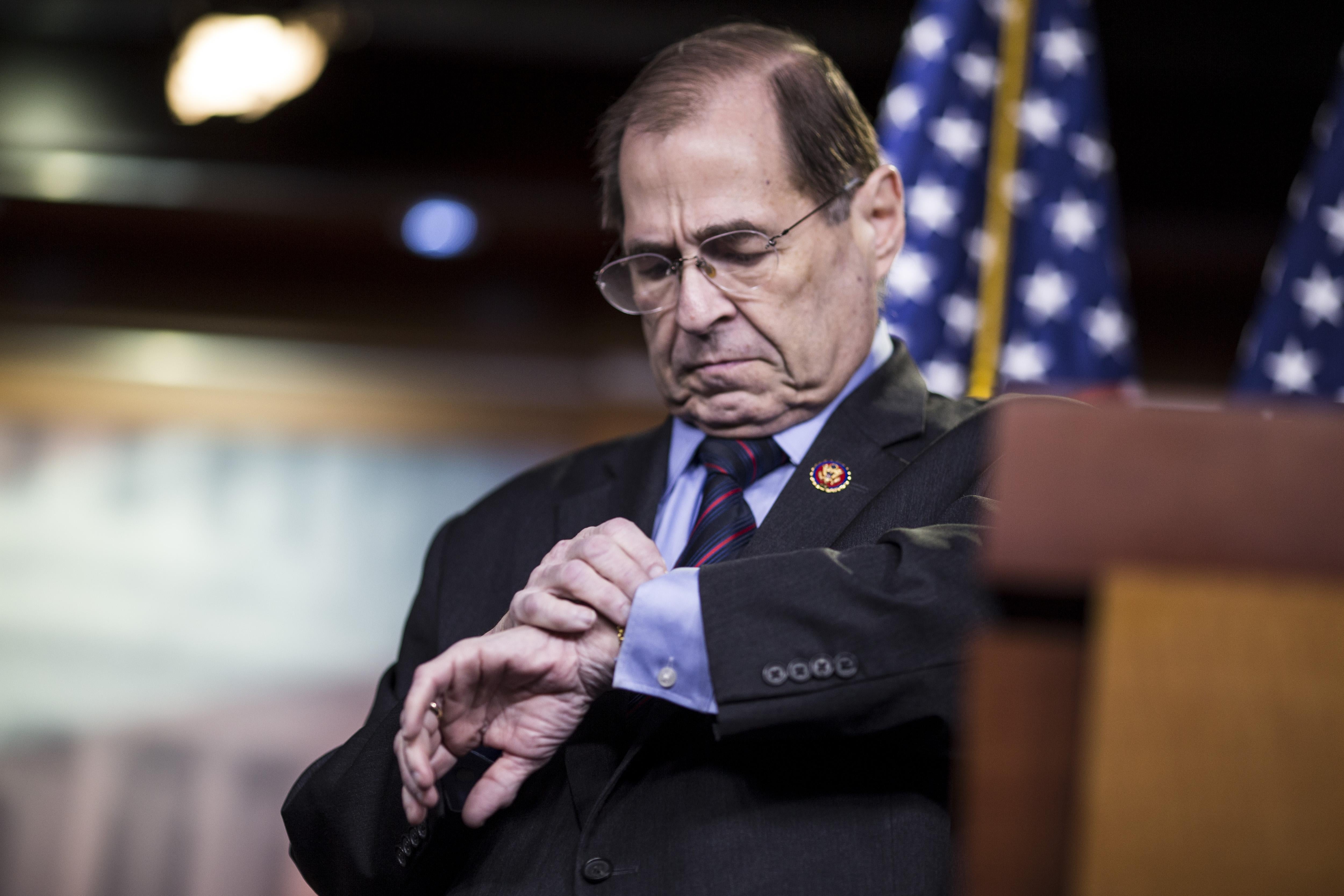 Jerry Nadler looks at his watch as he steps down from a podium.