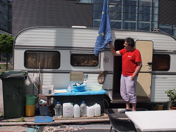 Balazs Nagy Navarro, a journalist who once worked for Hungary’s state television network, stands in front of the camper trailer that has served as his home during his long-term protest against his former employer