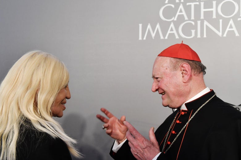 Italian designer Donatella Versace speaks to cardinal Gianfranco Ravasi.     