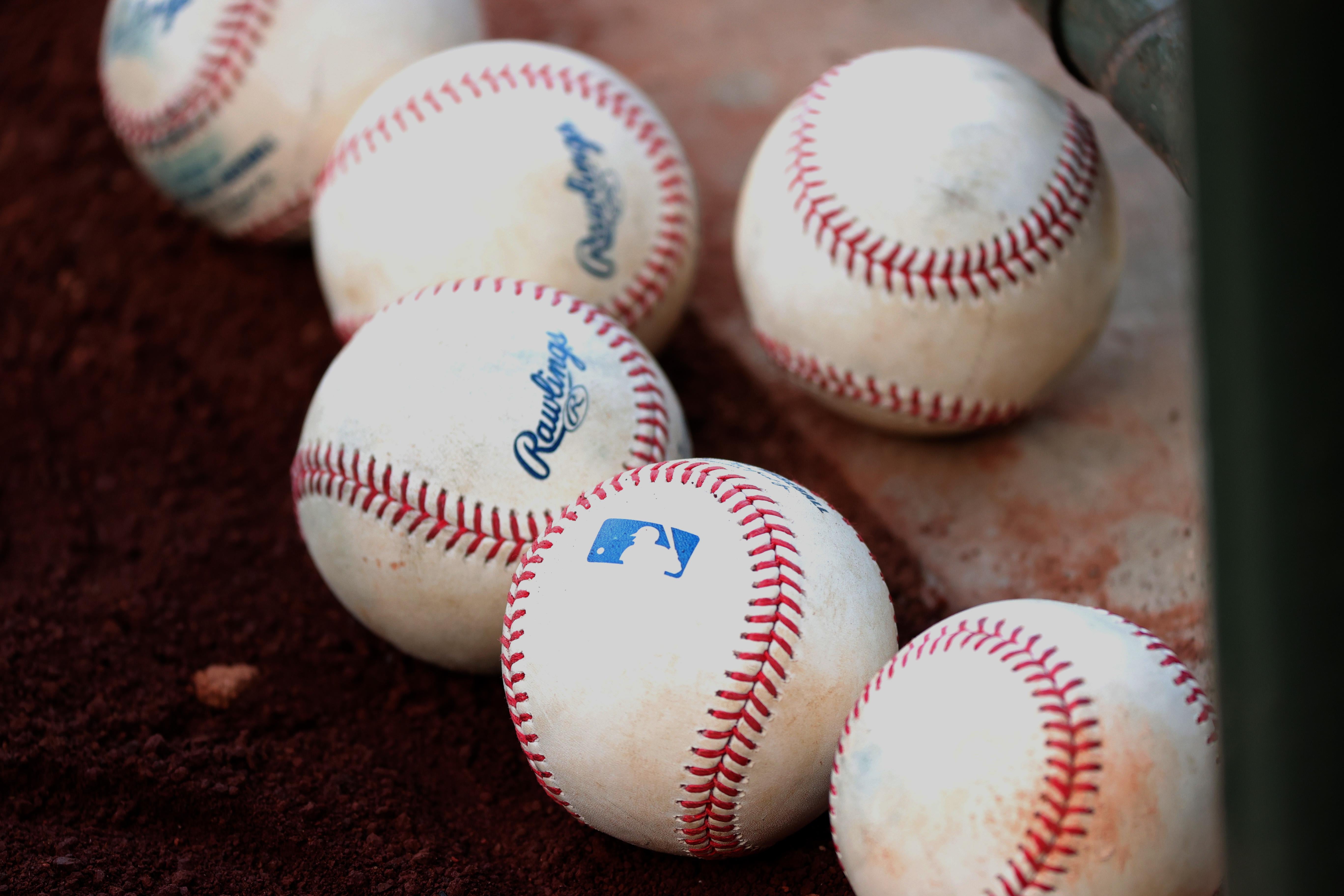 A bunch of baseballs on the ground.