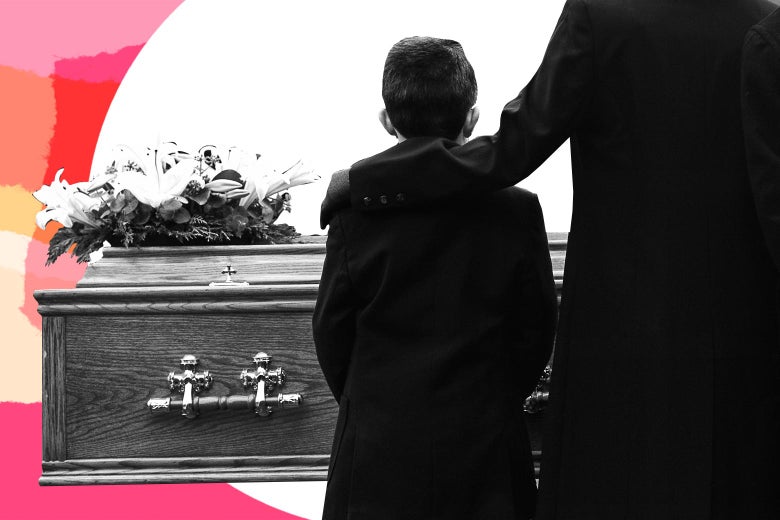 Boy dressed in a black with his mother's arm around him in front of a casket.