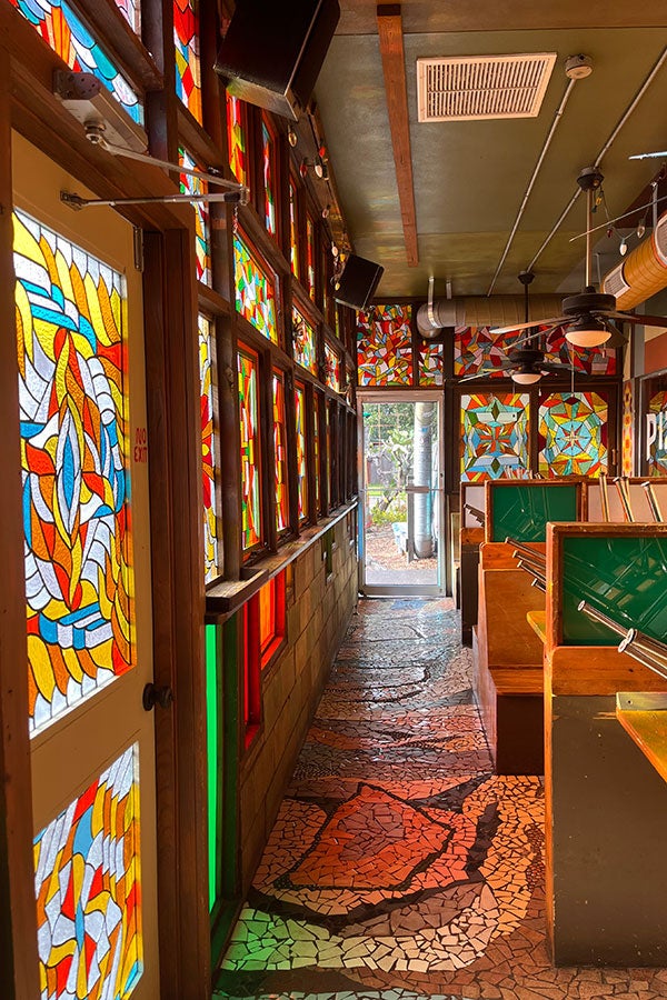 Interior of Satchel's, featuring bright stained glass.