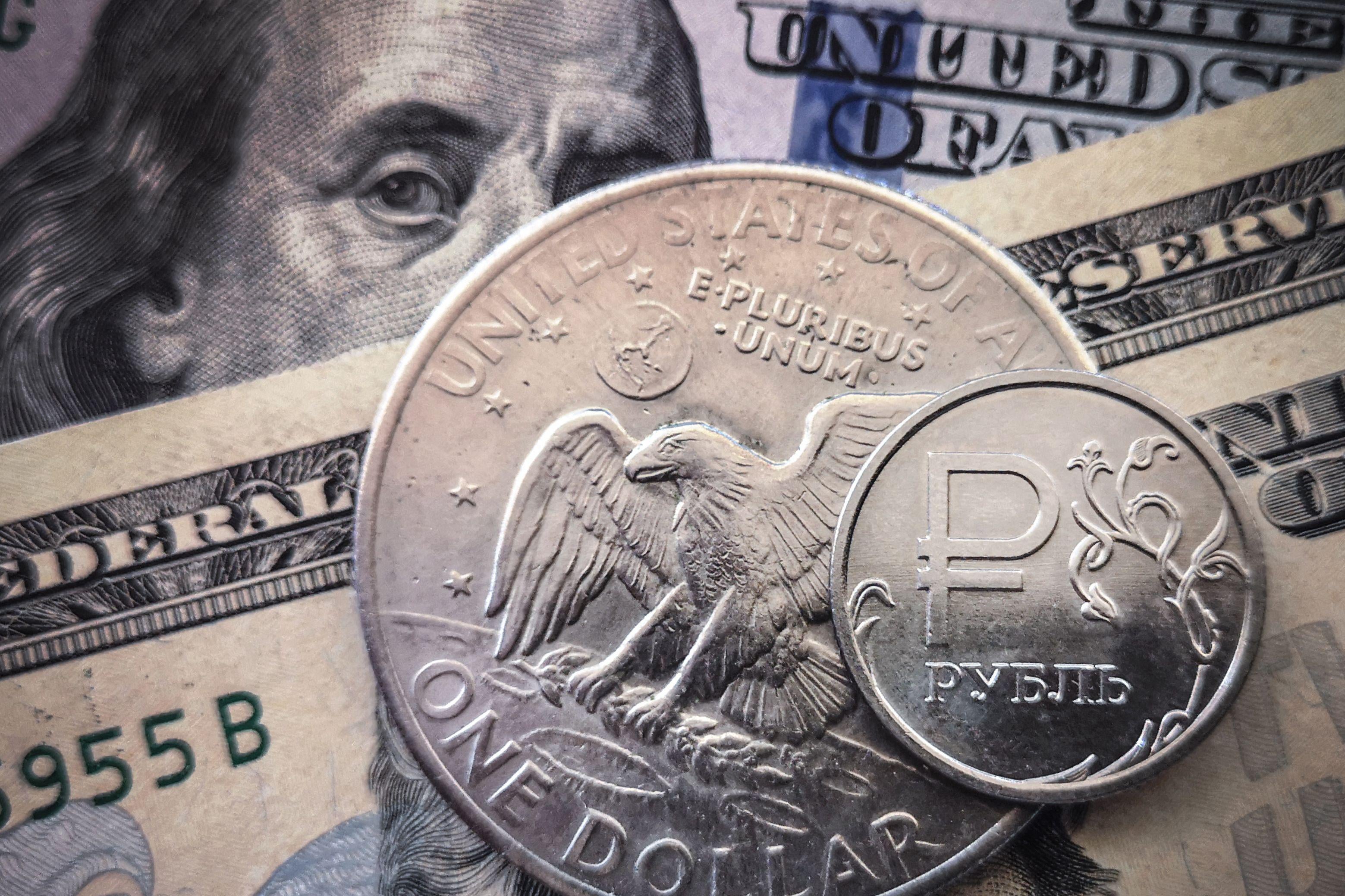 A Russian ruble coin with U.S. dollar bills and a $1 coin in Moscow.