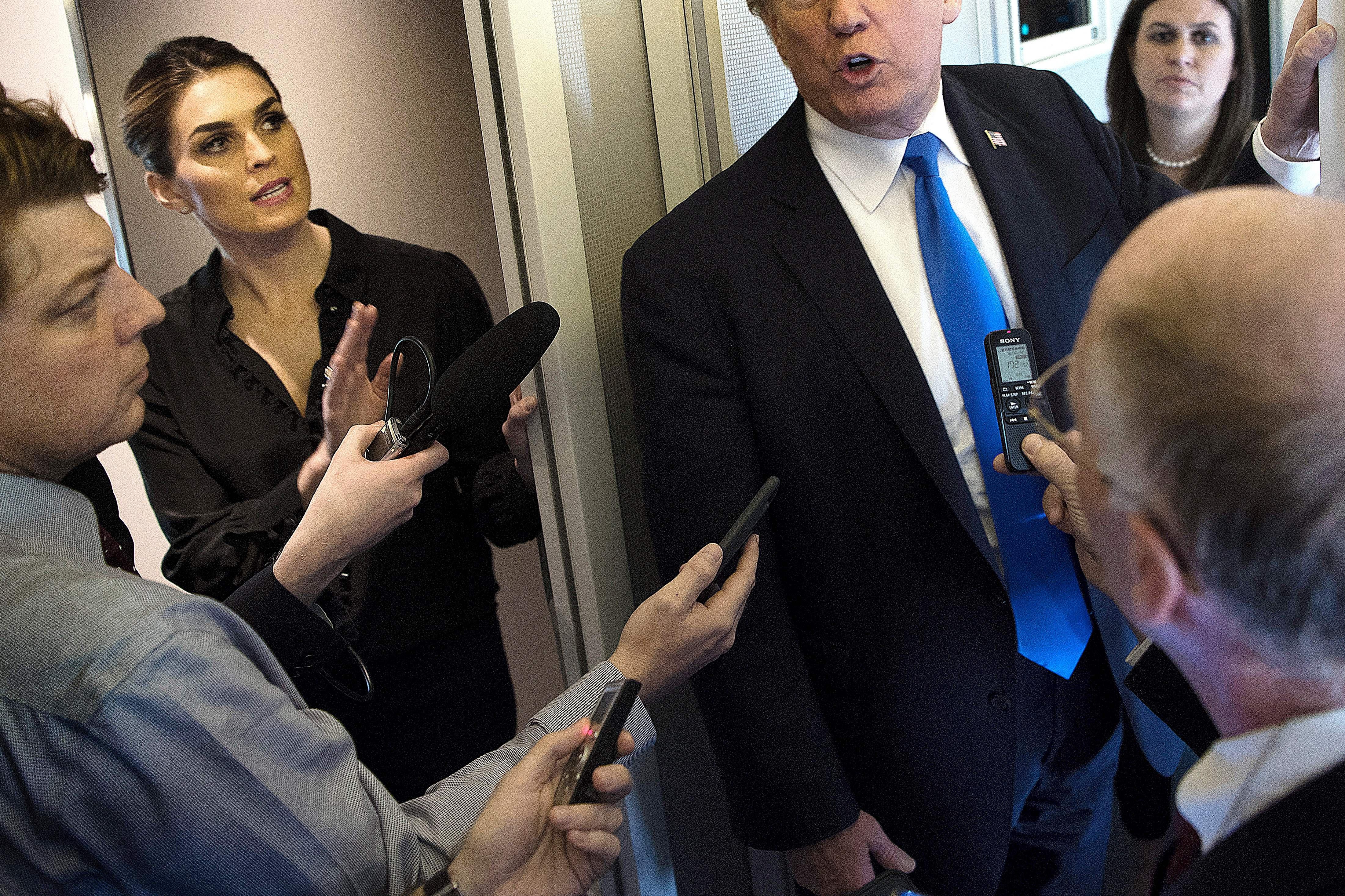White House Communications Director Hope Hicks and President Trump speak to reporters aboard Air Force One while departing Manila on Nov. 14, 2017. 