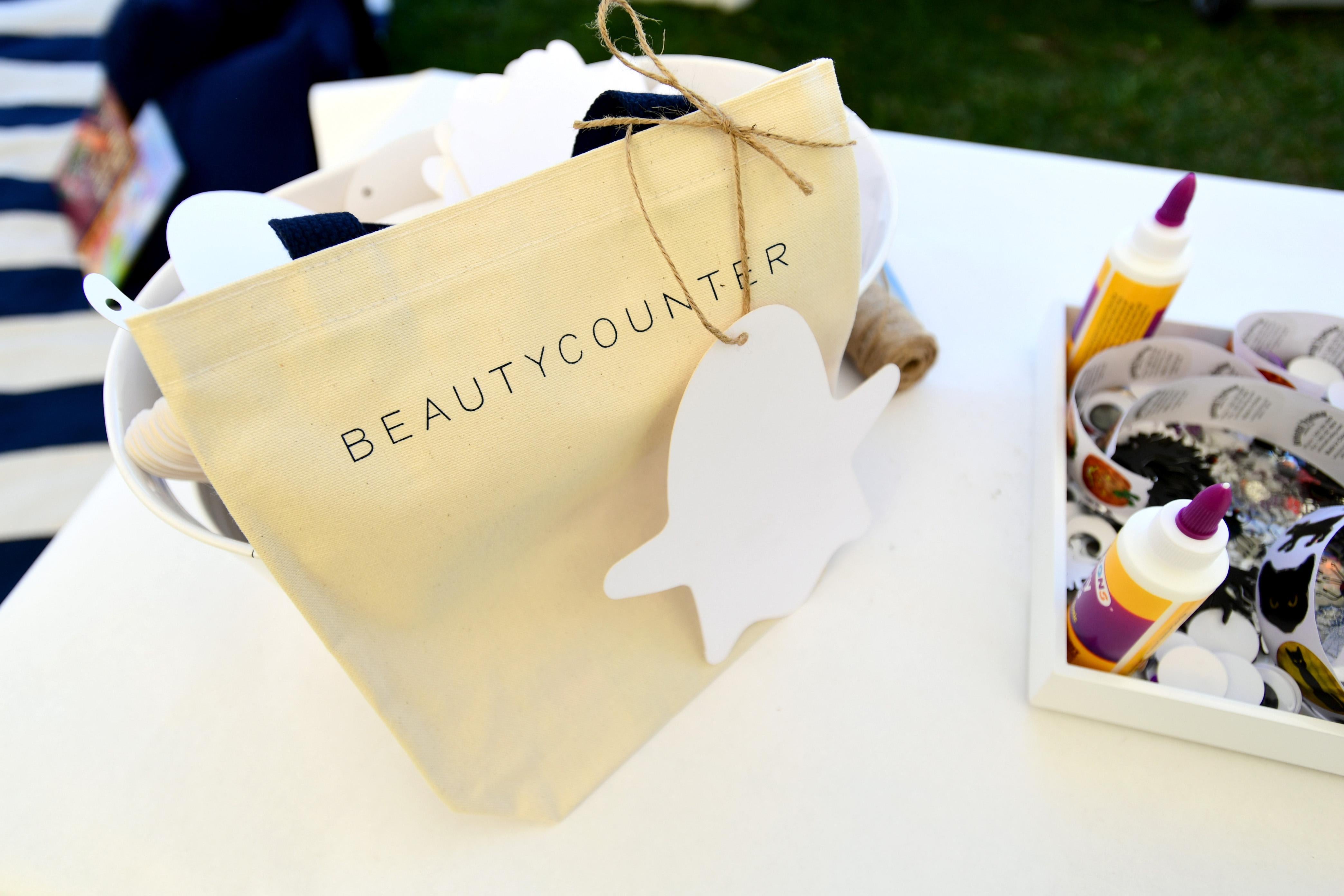 A yellow gift with Beautycounter on it sits on a white table.