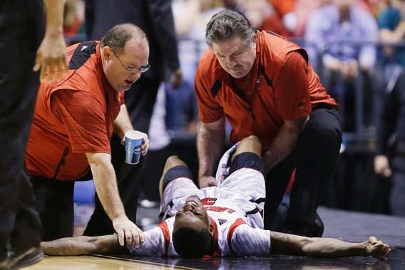 Trainers check on Louisville guard Kevin Ware (5) after an injury during the first half of the Midwest Regional final against Duke.