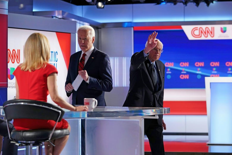 Joe Biden speaks to Dana Bash as Bernie Sanders waves and leaves the debate stage