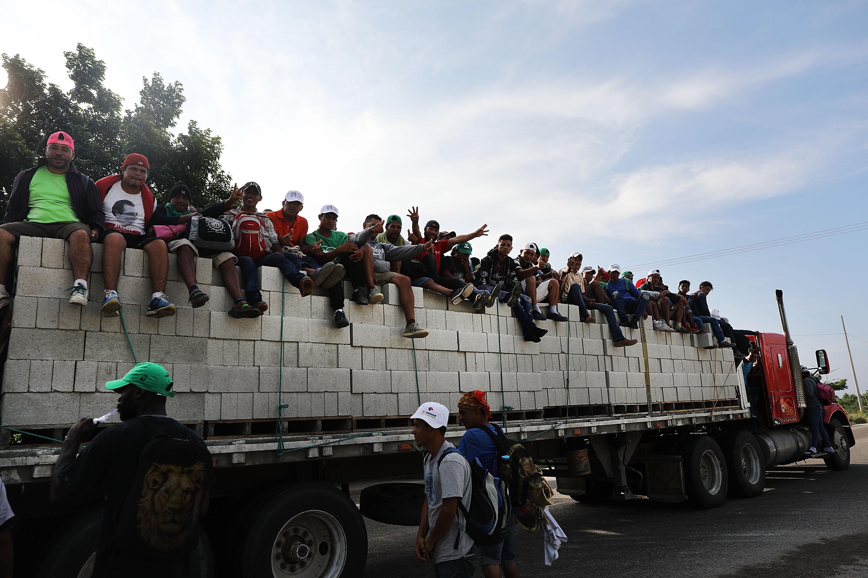 Some of the thousands of Central American migrants in the caravan get a lift to a camp.