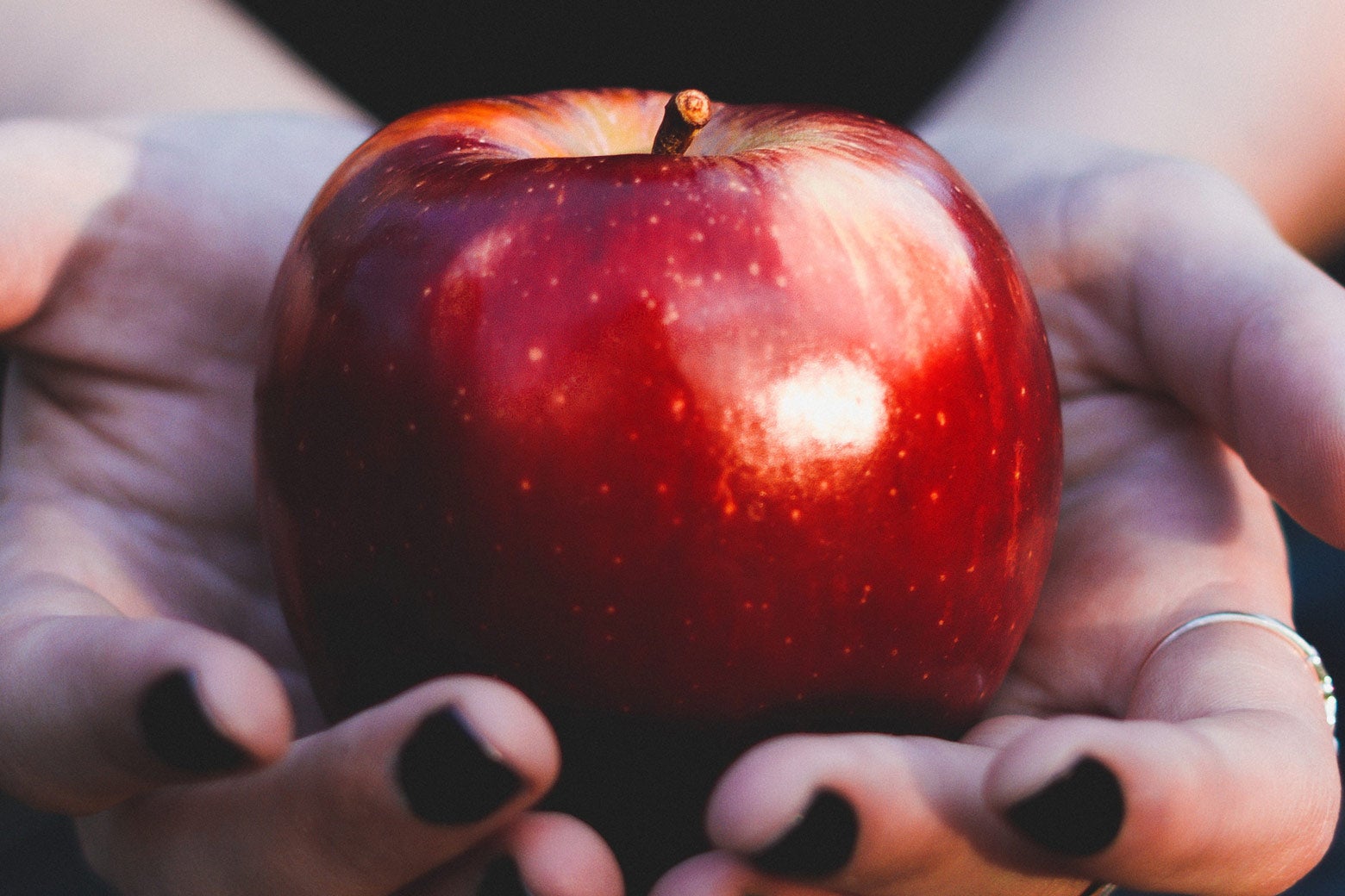 A Red Delicious apple held in someone's hands.