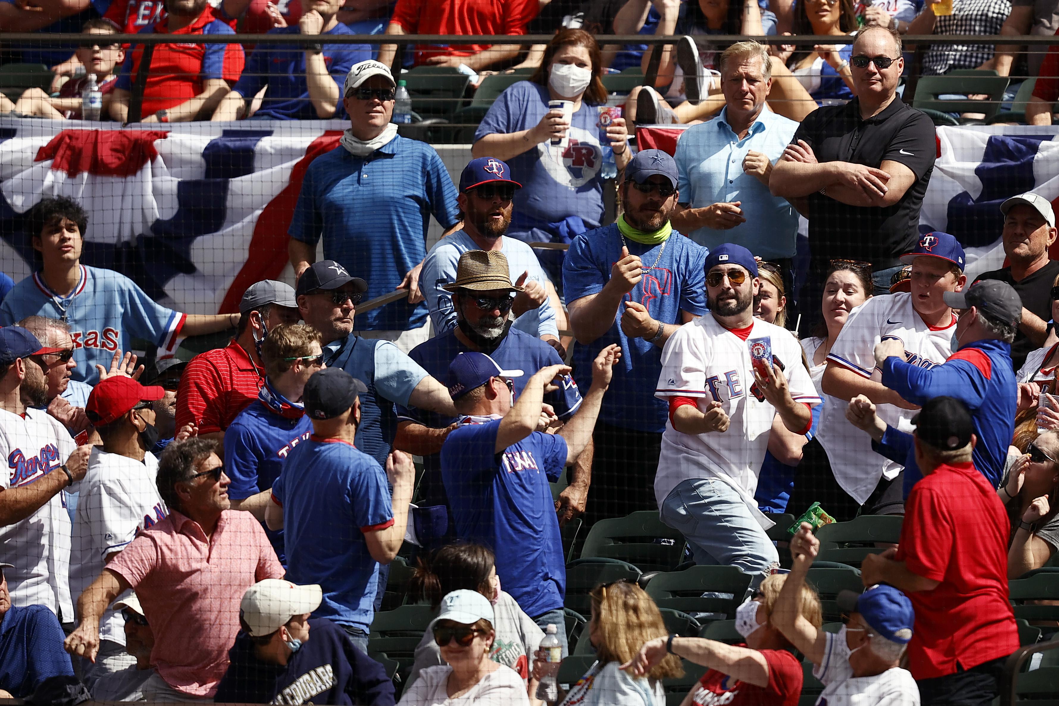 Fans in the stands scramble for a foul ball in the second inning