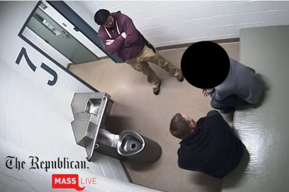 Still image from surveillance video of man and teen in a jail cell