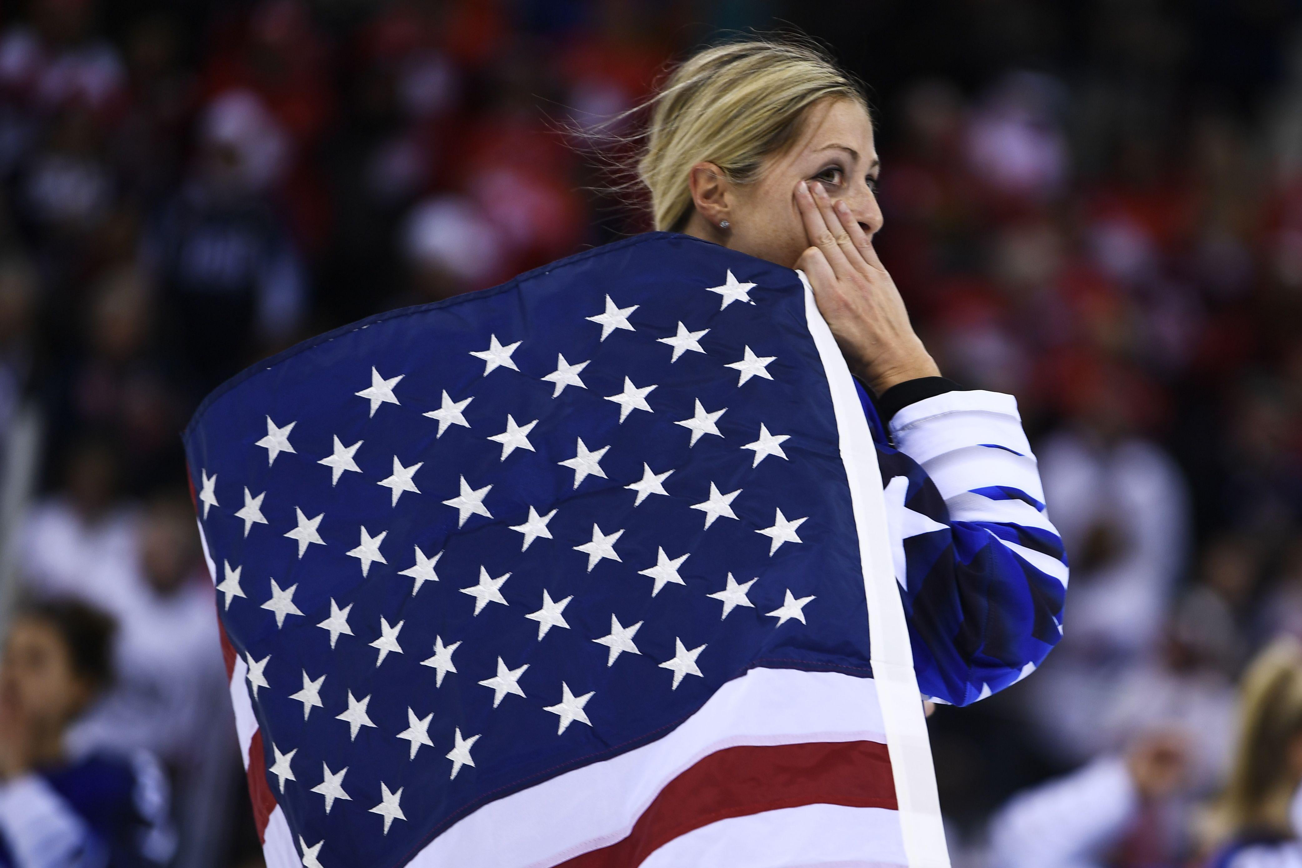 USA's Gigi Marvin holds the US flag after her team won the women's gold medal ice hockey match between the US and Canada during the Pyeongchang 2018 Winter Olympic Games at the Gangneung Hockey Centre in Gangneung on February 22, 2018.   / AFP PHOTO / Brendan Smialowski        (Photo credit should read BRENDAN SMIALOWSKI/AFP/Getty Images)