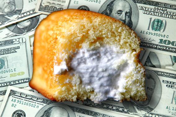 Hostess Twinkie hovering over pile of US Currency.