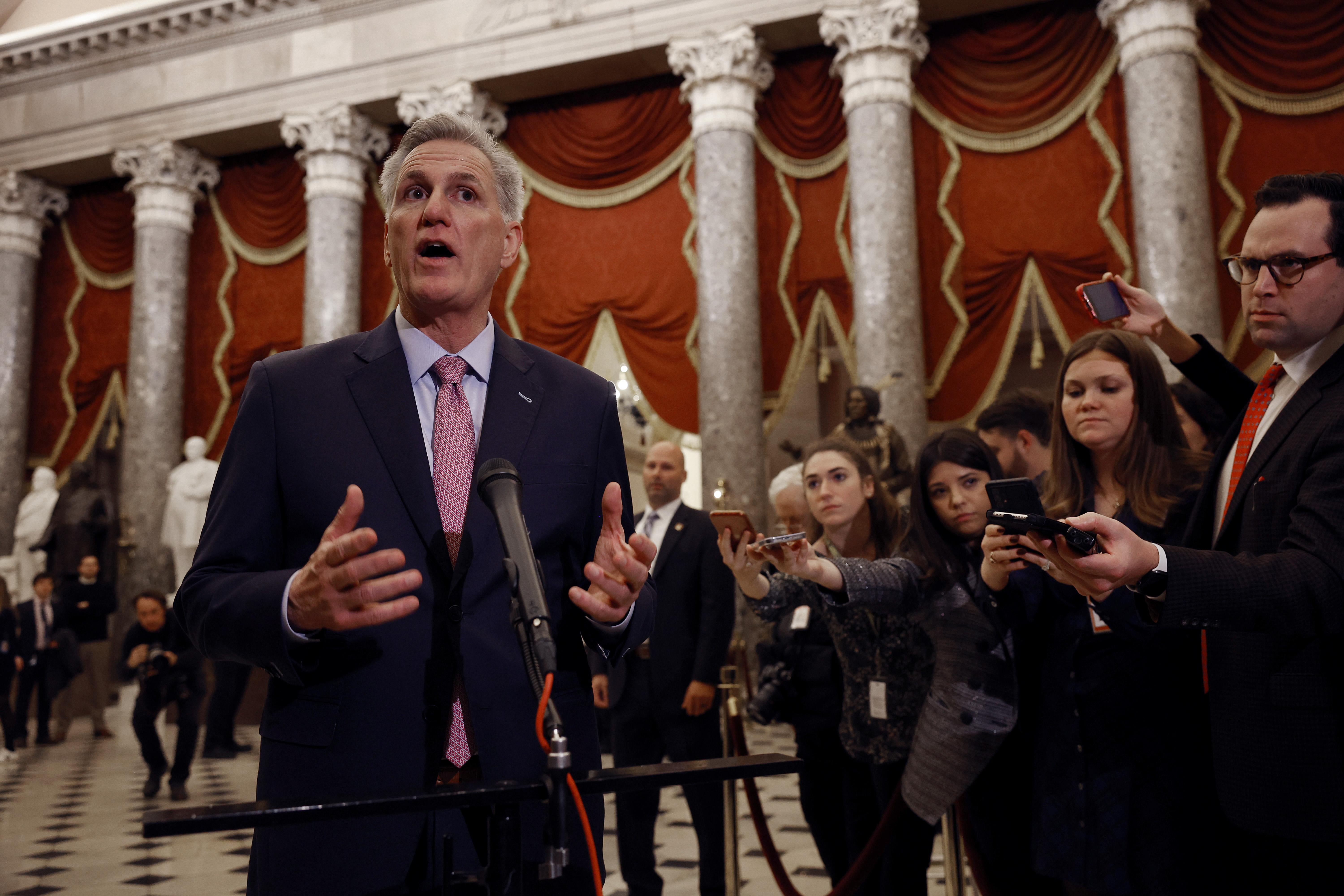 U.S. Speaker of the House Kevin McCarthy is standing in front of a row of reporters.