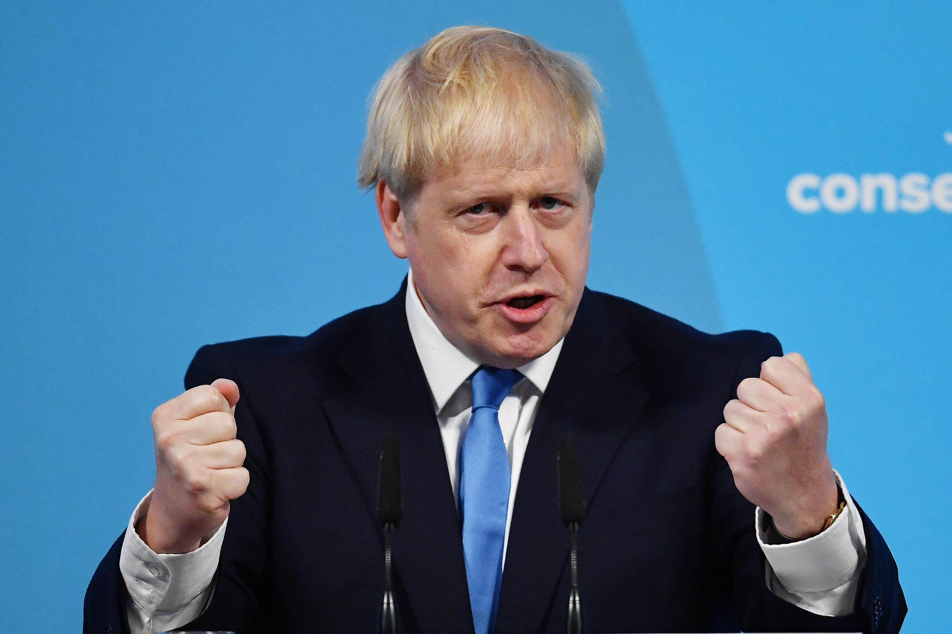 Boris Johnson holds up two fists.