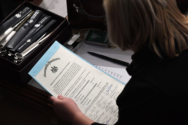 A person holds the certificate of votes from the Commonwealth of Pennsylvania above a desk
