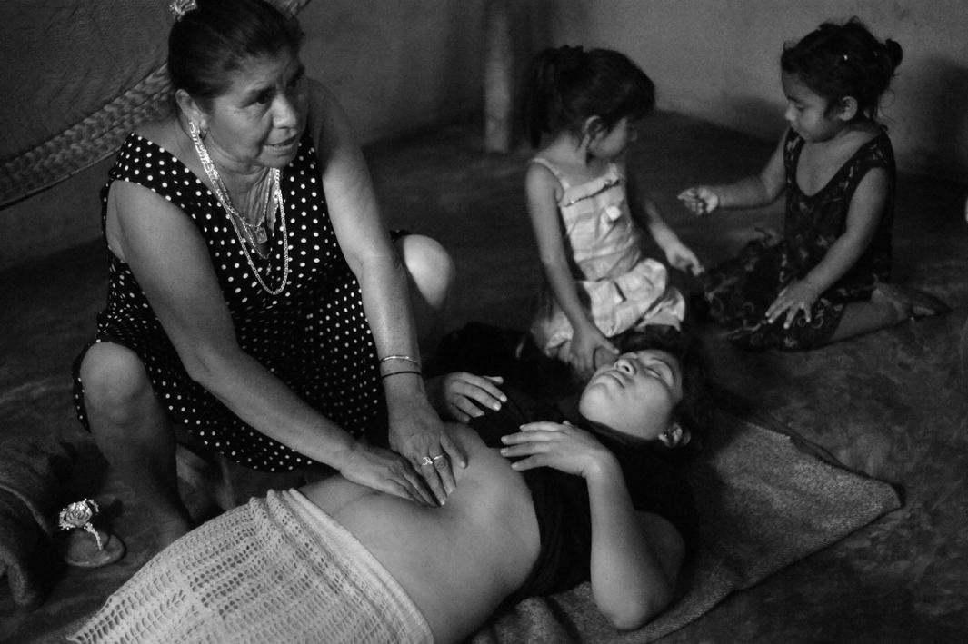 Traditional Mayan midwife Elsa Gonzalez Ayala shows CASA Midwifery School students how to perform a traditional Mayan massage used to shrink a woman's uterus and reduce post-partum bleeding - on Nelsi Marvella Tuk Balam.CASA Midwifery School students traveled to the rural village of Chunhuhub to learn traditional methods from traditional Mayan midwives and to teach them contemporary practices in exchange.