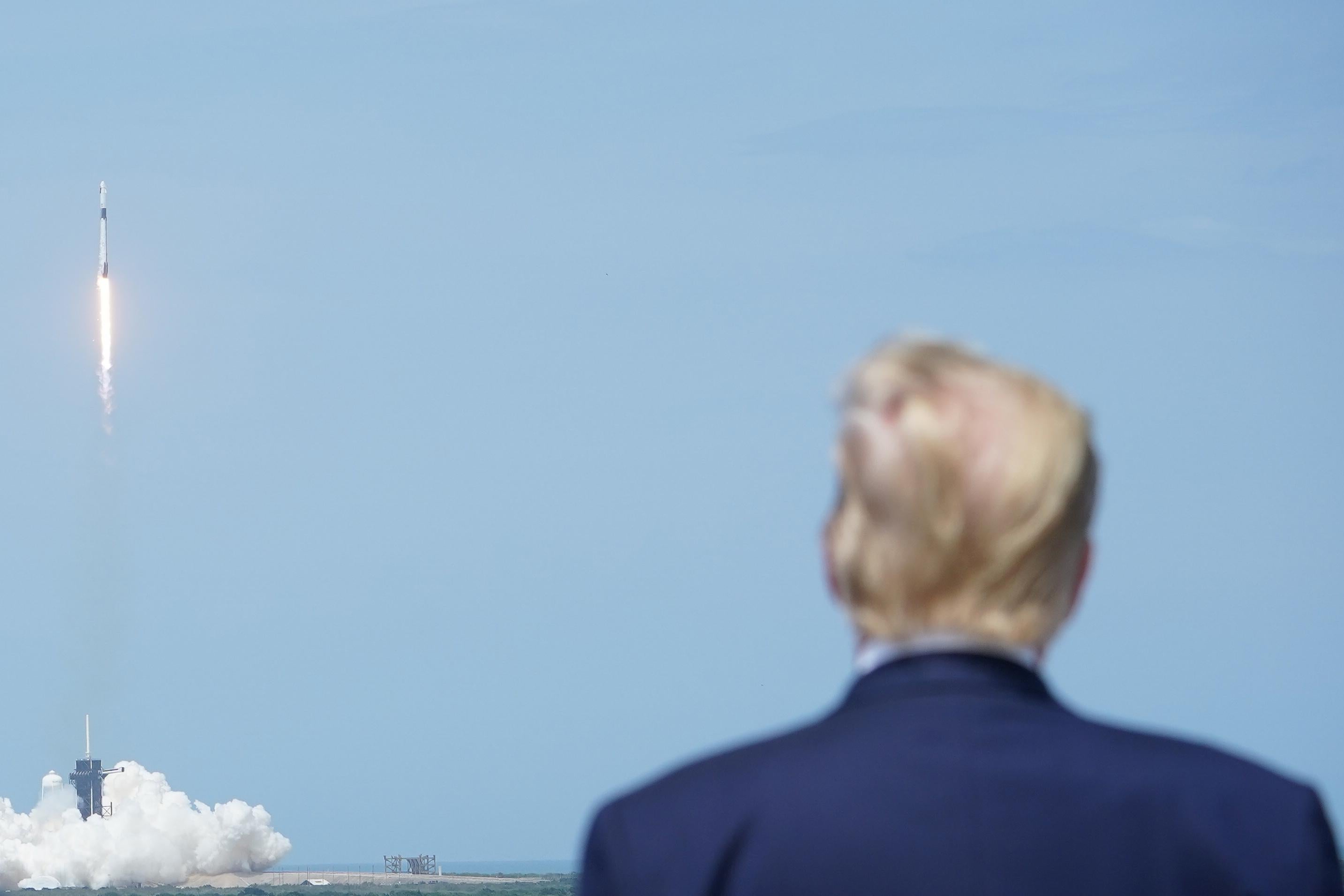 President Donald Trump watches the SpaceX Falcon 9 rocket carrying the SpaceX Crew Dragon capsule, with astronauts Bob Behnken and Doug Hurley, lift off from Kennedy Space Center in Florida on May 30, 2020.