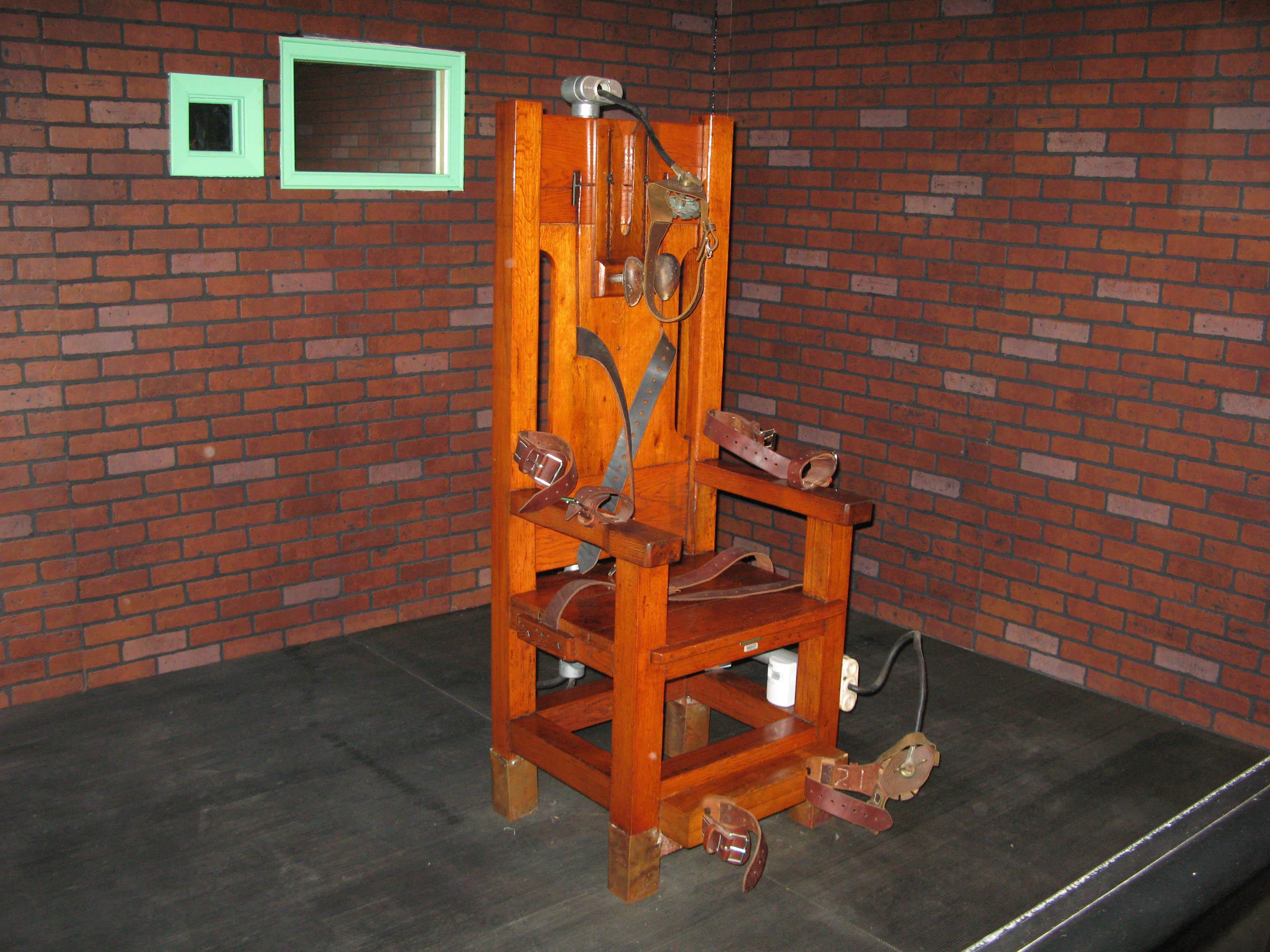 A wooden chair with straps and electric devices, looks very much like an old torture implement. 