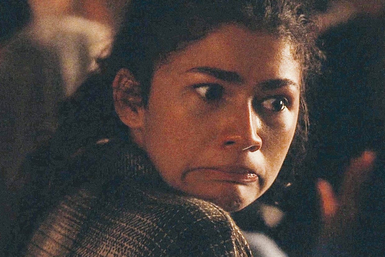 Still of Zendaya turning and grimacing as she hunches over in a seat in a darkened auditorium