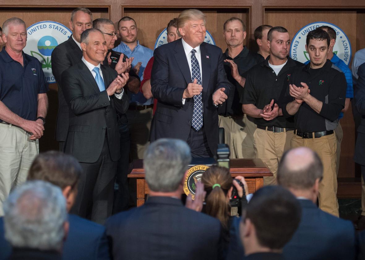 Surrounded by miners from Rosebud Mining, US President Donald Trump (C) applauds after signing the Energy Independence Executive Order at the Environmental Protection Agency 