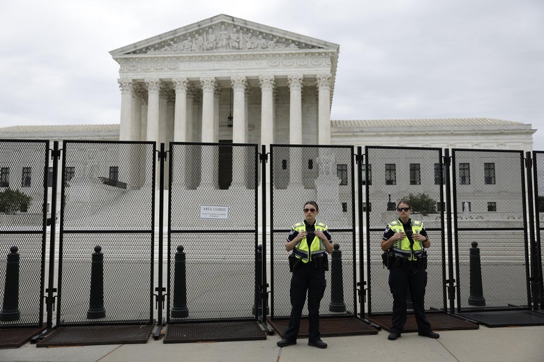  Police officers with the U.S. Supreme Court Building stand in front of a temporary security fence on June 21, 2022 in Washington, DC.