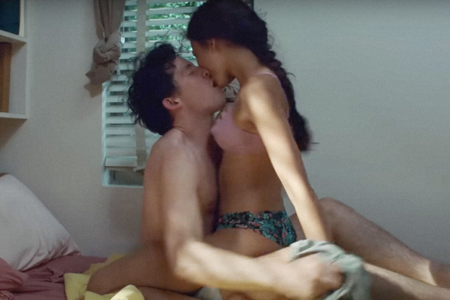 Josh O'Connor and Zendaya make out on a dorm-room bed.