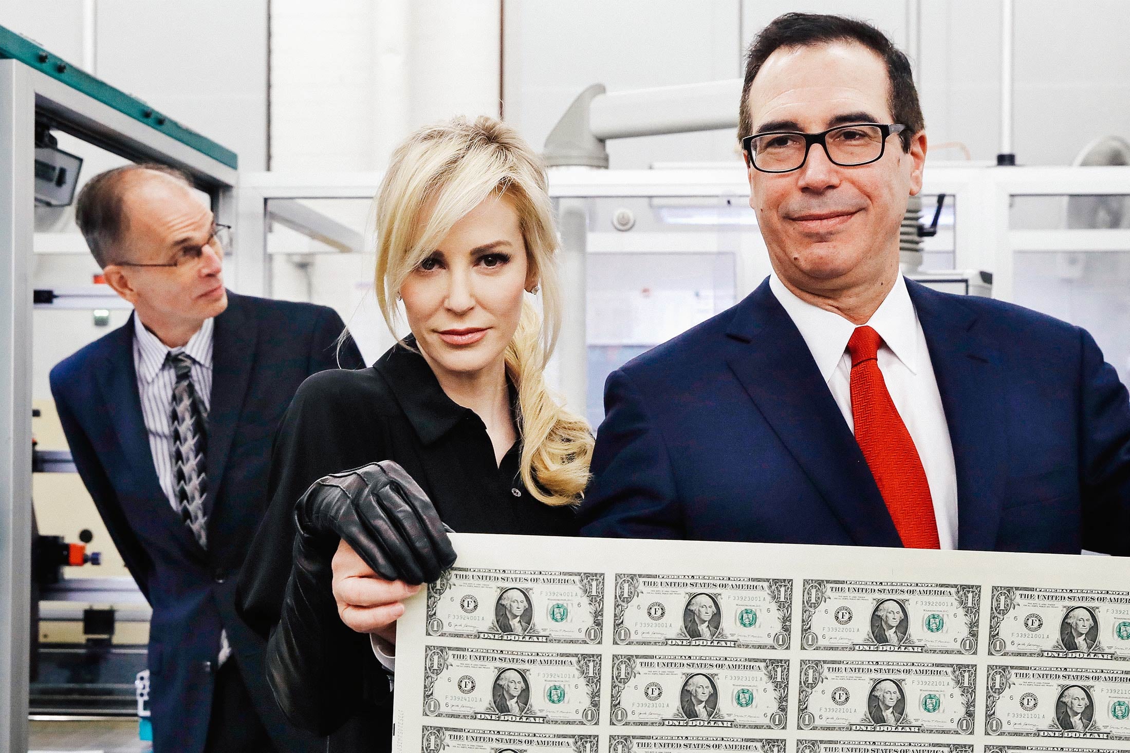 Treasury Secretary Steve Mnuchin and his wife Louise Linton holding up a sheet of new dollar bills at the Bureau of Engraving and Printing in Washington,  D.C. on Nov. 15, 2017.